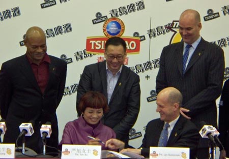 Cleveland Cavalier legend Austin Carr, QSL CEO Kenny Huang and Cavs GM Danny Ferry watch as Tsingtao's Ms. Xu Yan and Len Komoroski sign the agreement