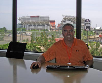 Aztek CEO John Hill in their new conference room with Cleveland Browns Stadium in the background